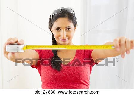 Mixed race woman using measuring tape View Large Photo Image Stock Image - Mixed race woman using measuring tape. Fotosearch