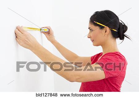Mixed race woman using measuring tape View Large Photo Image Stock Photo - Mixed race woman using measuring tape. Fotosearch