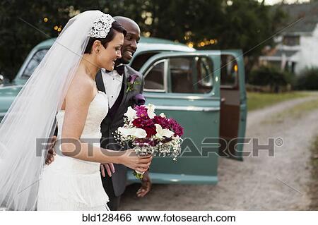 Newlywed couple outside vintage car View Large Photo Image Stock Photograph - Newlywed couple outside vintage car. Fotosearch