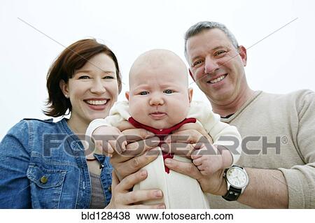 Parents holding baby outdoors View Large Photo Image Stock Photo - Parents holding baby outdoors. Fotosearch