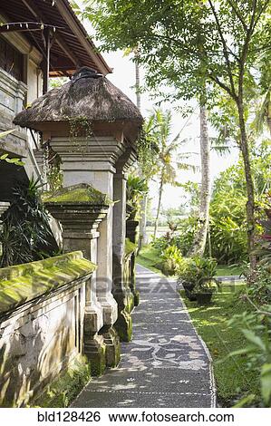 Stock Photograph - Pathway along moss covered stone building. Fotosearch