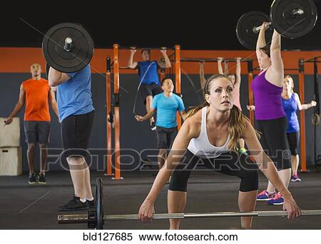 Stock Photography - People lifting weights in gym. Fotosearch