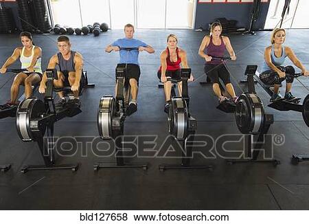 Stock Photo - People using rowing machines in gym. Fotosearch
