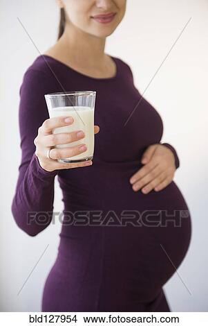 Picture - Pregnant Caucasian woman holding glass of milk. Fotosearch