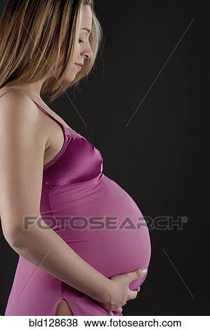 Pregnant Caucasian woman holding her belly View Large Photo Image Stock Photo - Pregnant Caucasian woman holding her belly. Fotosearch