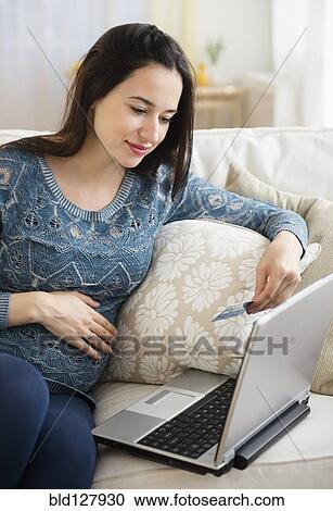 Stock Image - Pregnant Caucasian woman shopping online. Fotosearch