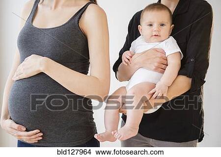 Picture - Pregnant Caucasian woman with friend and baby. Fotosearch