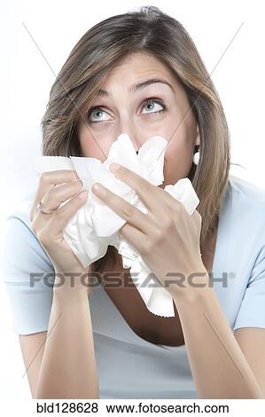 Stock Photo - Woman blowing her nose into tissues. Fotosearch