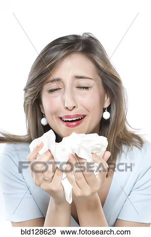 Stock Photo - Woman sneezing into tissues. Fotosearch