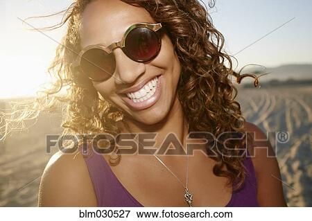 Stock Photo - African American woman smiling on beach. Fotosearch