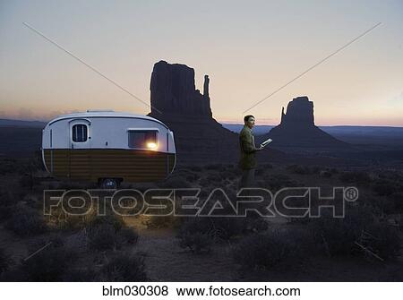 Stock Photo - Asian scientist parking trailer in desert landscape. Fotosearch