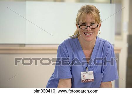 Stock Image - Caucasian doctor smiling in hospital. Fotosearch