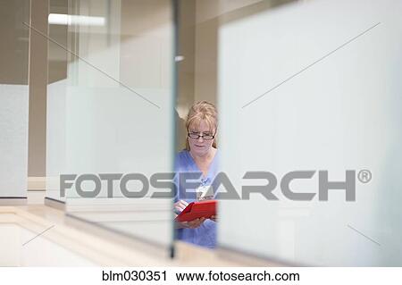 Stock Image - Caucasian nurse using digital tablet in hospital. Fotosearch