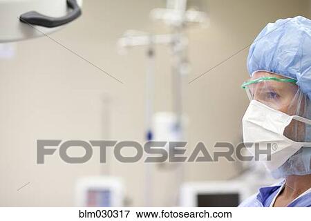 Stock Photo - Caucasian surgeon wearing mask in operating room. Fotosearch