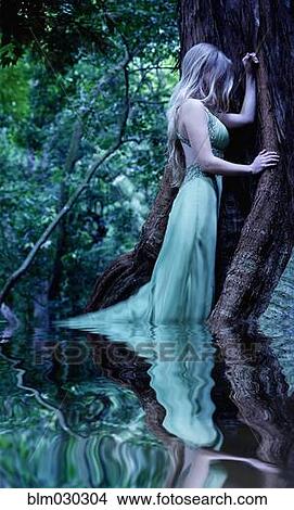 Picture - Caucasian woman standing in pool in forest. Fotosearch