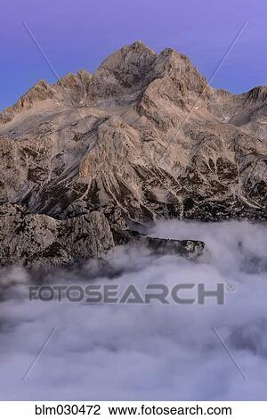 Clouds rolling over The Alps mountains, Triglav, Gorenjska, Slovenia View Large Photo Image Stock Image - Clouds rolling over The Alps mountains, Triglav, Gorenjska, Slovenia. Fotosearch