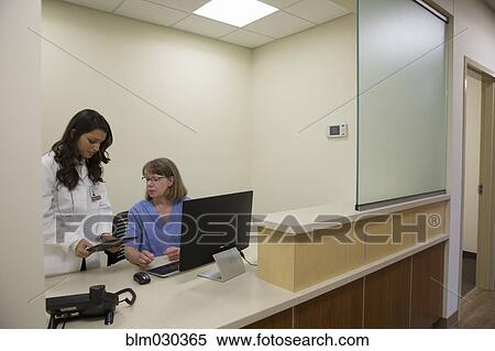 Doctor and nurse talking at nurses station View Large Photo Image Stock Photography - Doctor and nurse talking at nurses station. Fotosearch
