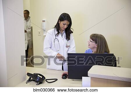 Doctor and nurse talking in hospital reception View Large Photo Image Stock Photograph - Doctor and nurse talking in hospital reception. Fotosearch