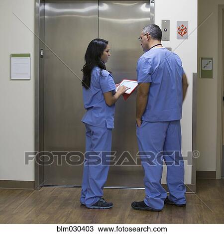 Stock Image - Doctors discussing patient's chart in hospital. Fotosearch