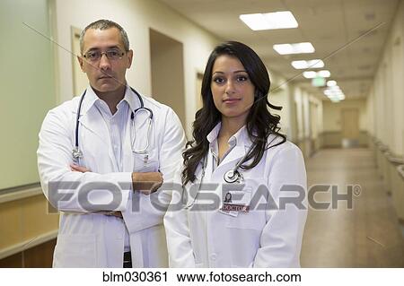 Stock Image - Doctors standing in hospital corridor. Fotosearch