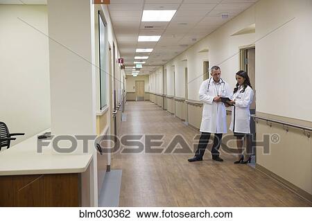 Doctors talking in hospital corridor View Large Photo Image Stock Image - Doctors talking in hospital corridor. Fotosearch