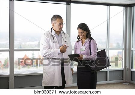 Stock Image - Doctors talking in hospital. Fotosearch