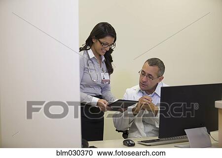 Stock Image - Doctors talking in office. Fotosearch