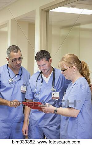 Stock Image - Doctors using digital tablet in hospital. Fotosearch