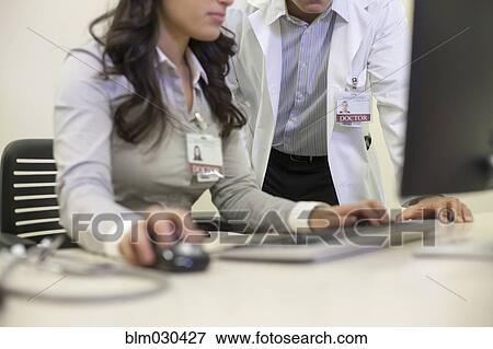Stock Photo - Doctors working on computer in office. Fotosearch