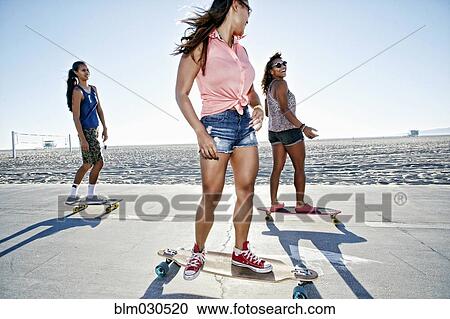 Friends riding longboards on beach View Large Photo Image Stock Image - Friends riding longboards on beach. Fotosearch