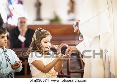 Girl taking her first communion at church View Large Photo Image Picture - Girl taking her first communion at church. Fotosearch