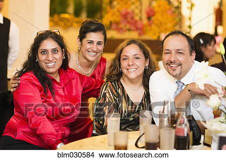 Picture - Hispanic family smiling at wedding reception. Fotosearch