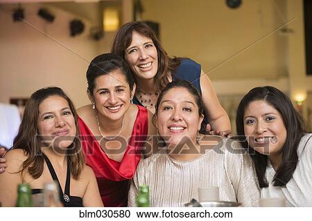 Stock Image - Hispanic family smiling at wedding reception. Fotosearch