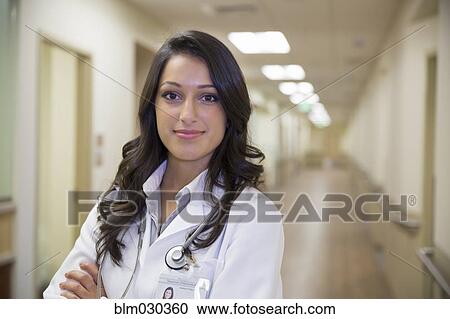 Mixed race doctor standing in hospital corridor View Large Photo Image Stock Image - Mixed race doctor standing in hospital corridor. Fotosearch