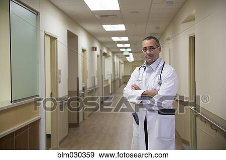 Stock Photo - Mixed race doctor standing in hospital corridor. Fotosearch