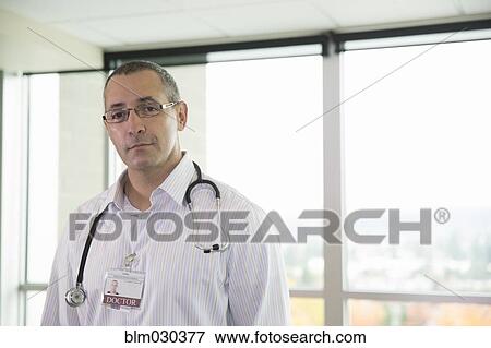Mixed race doctor standing in hospital View Large Photo Image Stock Photo - Mixed race doctor standing in hospital. Fotosearch