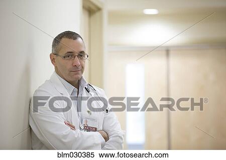 Stock Photography - Mixed race doctor standing in hospital corridor. Fotosearch