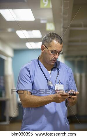 Mixed race doctor using cell phone in hospital View Large Photo Image Stock Photography - Mixed race doctor using cell phone in hospital. Fotosearch