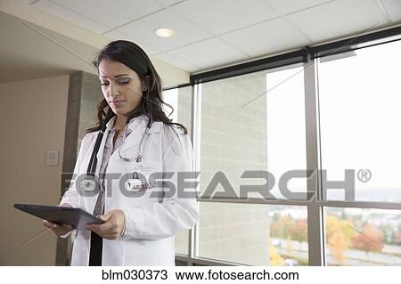 Mixed race doctor using digital tablet in hospital View Large Photo Image Stock Image - Mixed race doctor using digital tablet in hospital. Fotosearch