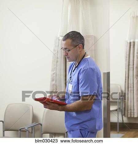 Mixed race doctor using digital tablet in hospital corridor View Large Photo Image Stock Image - Mixed race doctor using digital tablet in hospital corridor. Fotosearch