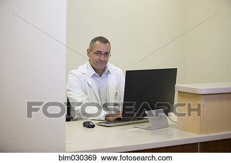 Stock Photo - Mixed race doctor working in office. Fotosearch