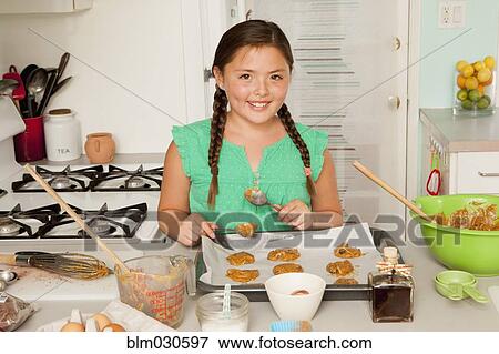 Stock Photo - Mixed race girl baking in kitchen. Fotosearch