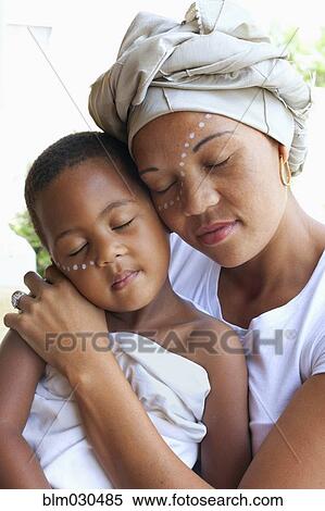 Stock Photography - Mixed race mother and daughter hugging. Fotosearch