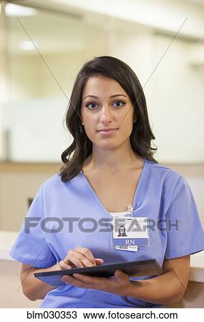 Stock Image - Mixed race nurse using digital tablet in hospital. Fotosearch