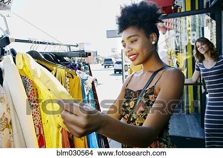 Picture - Mixed race woman shopping on city street. Fotosearch