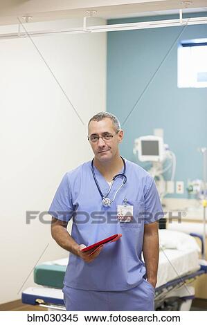 Stock Photography - Nurse carrying digital tablet in hospital. Fotosearch