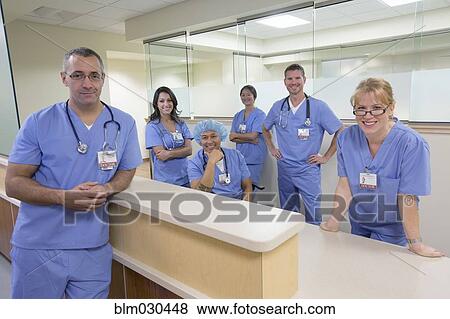 Nurses and doctors smiling at nurses station View Large Photo Image Stock Photo - Nurses and doctors smiling at nurses station. Fotosearch
