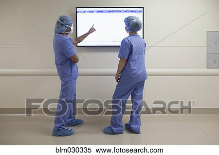 Nurses reading monitor in hospital corridor View Large Photo Image Stock Photography - Nurses reading monitor in hospital corridor. Fotosearch