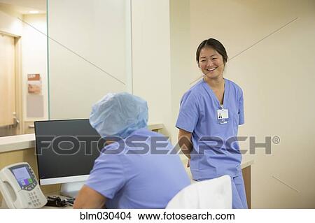 Picture - Nurses talking in hospital room. Fotosearch