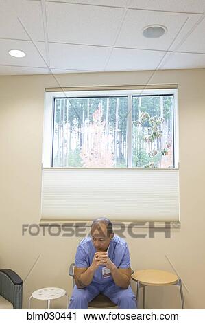 Stock Image - Pacific Islander nurse sitting in hospital room. Fotosearch